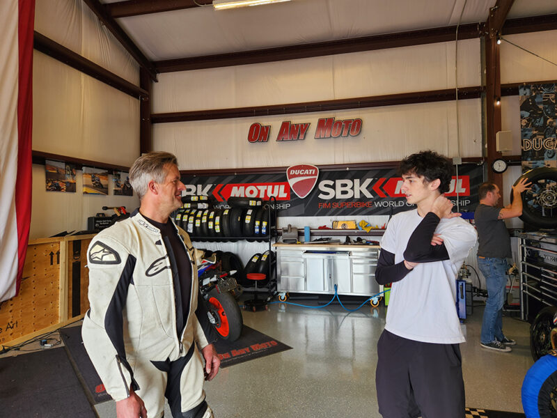 Marc talking to another track day participant inside On Any Moto's garage at Inde.