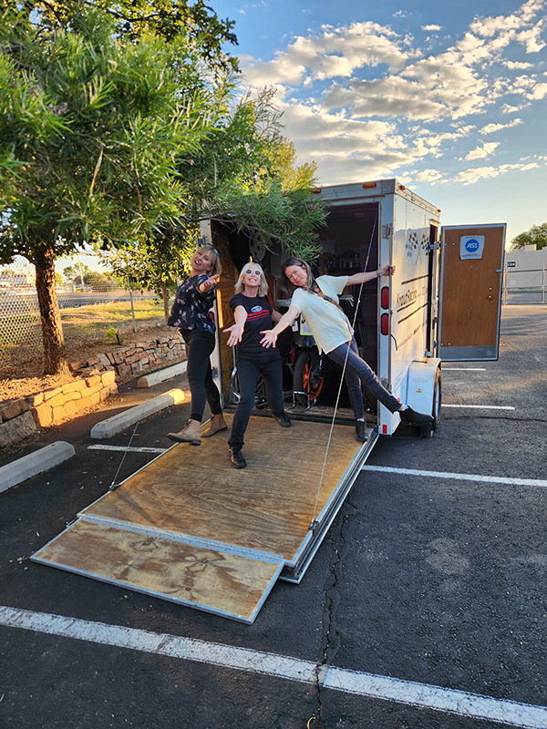 Adah, Frances, and Abigail posing on the ramp of the race trailer before driving down to the All Girls Track Day at ASMA